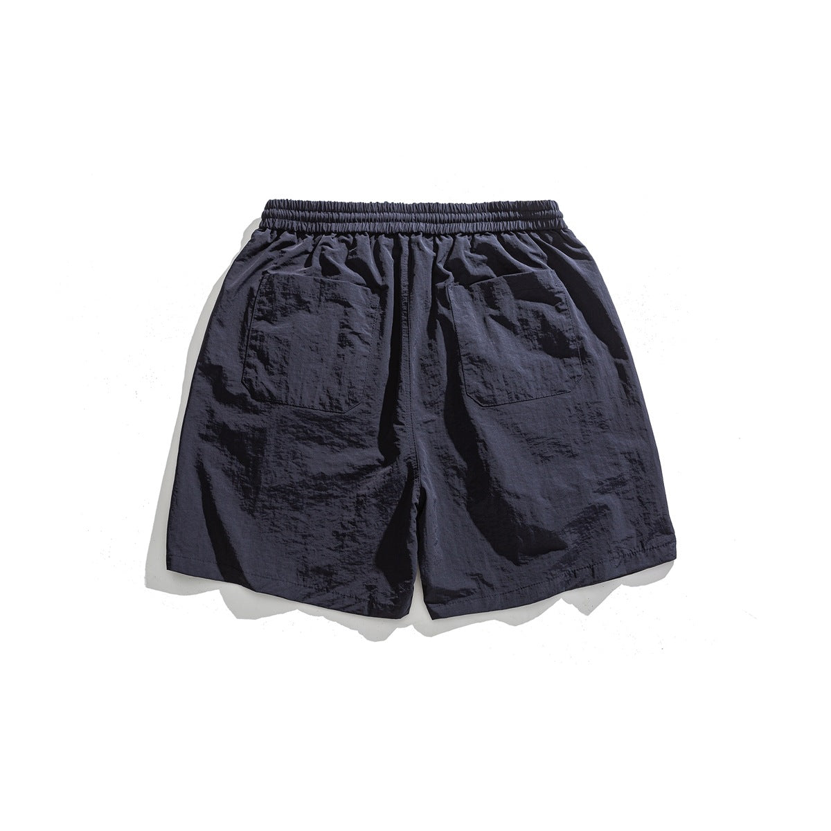 Back view of dark navy shorts with an elastic waistband and two large patch pockets.