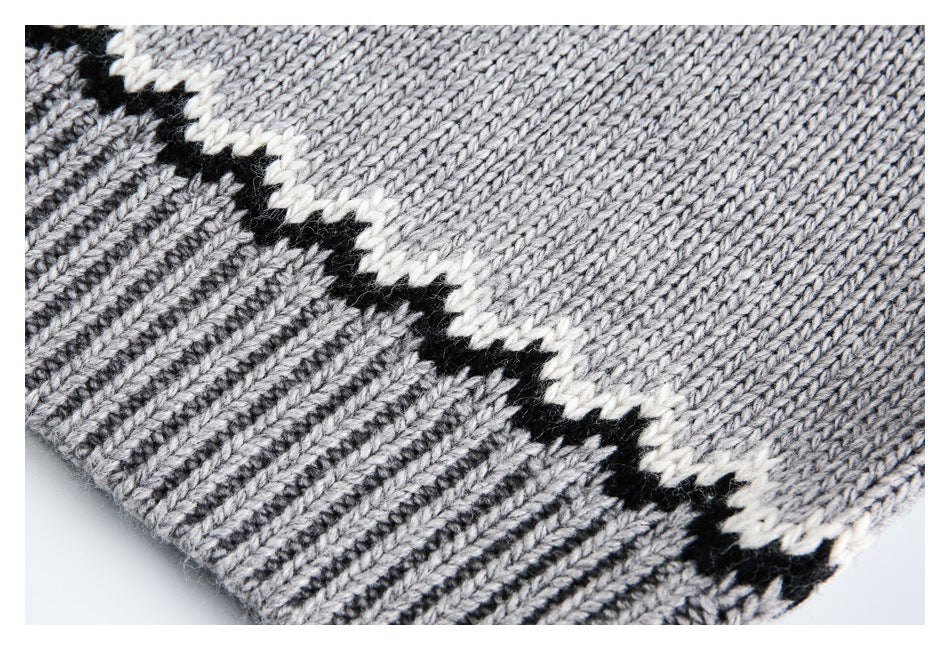 Close-up of the gray knit sweater hem with a ribbed edge and a black-and-cream zigzag border.