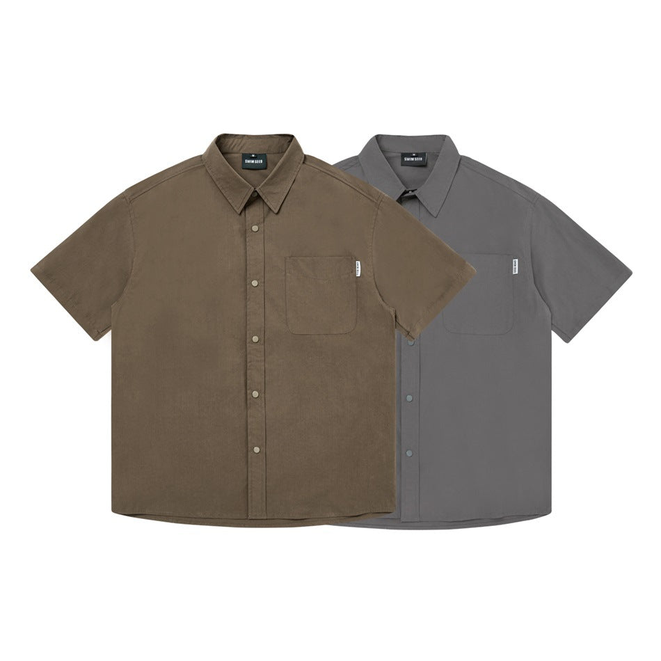 Two flat-lay short-sleeve button-up shirts with chest pockets, one brown and one gray.