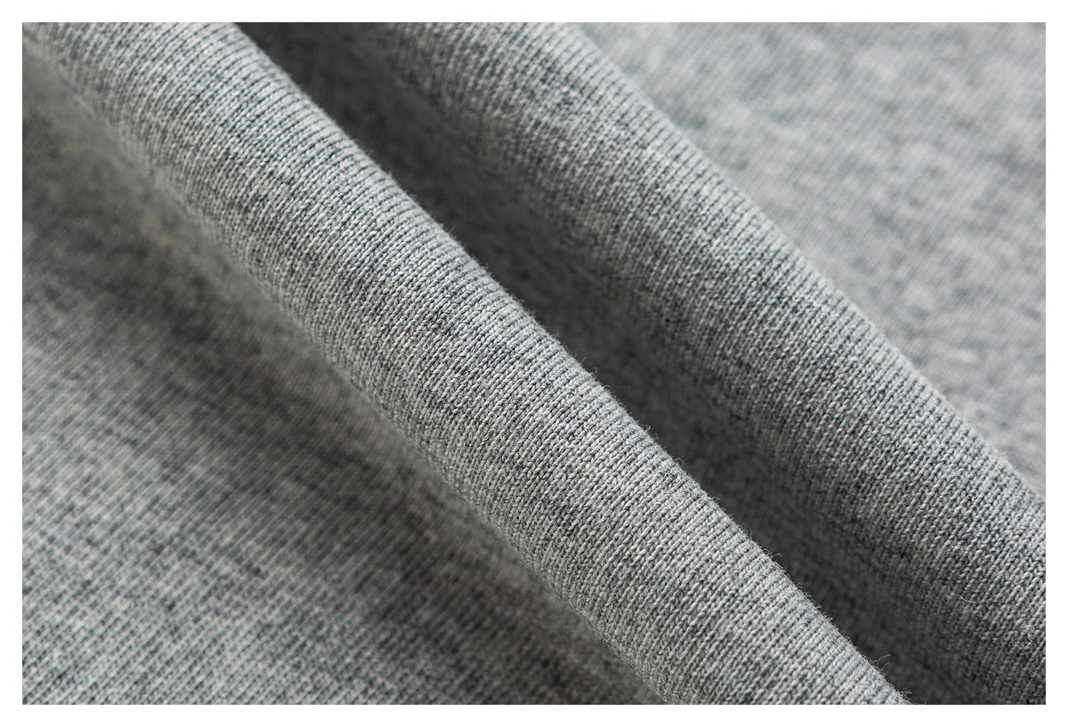 Macro view of the heathered knit texture of gray shirt fabric folded into soft ridges.