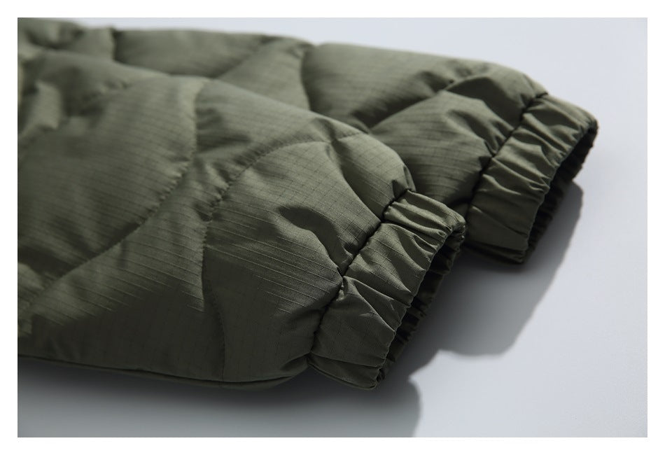 Close-up of an olive quilted garment sleeve with gathered elastic cuffs.