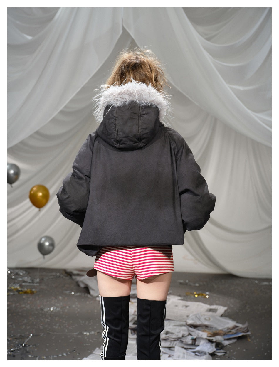 Closer rear view of a model in a dark jacket with pale fur-trimmed hood and red-and-white striped shorts.