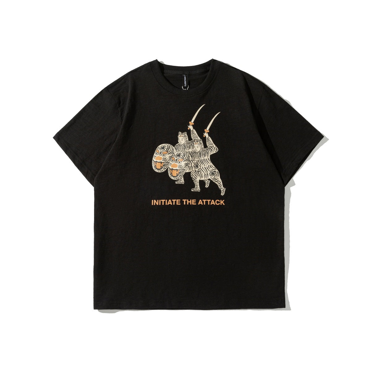 Black short-sleeve crew-neck T-shirt with tiger-costume sword graphic and orange INITIATE THE ATTACK text, flat lay