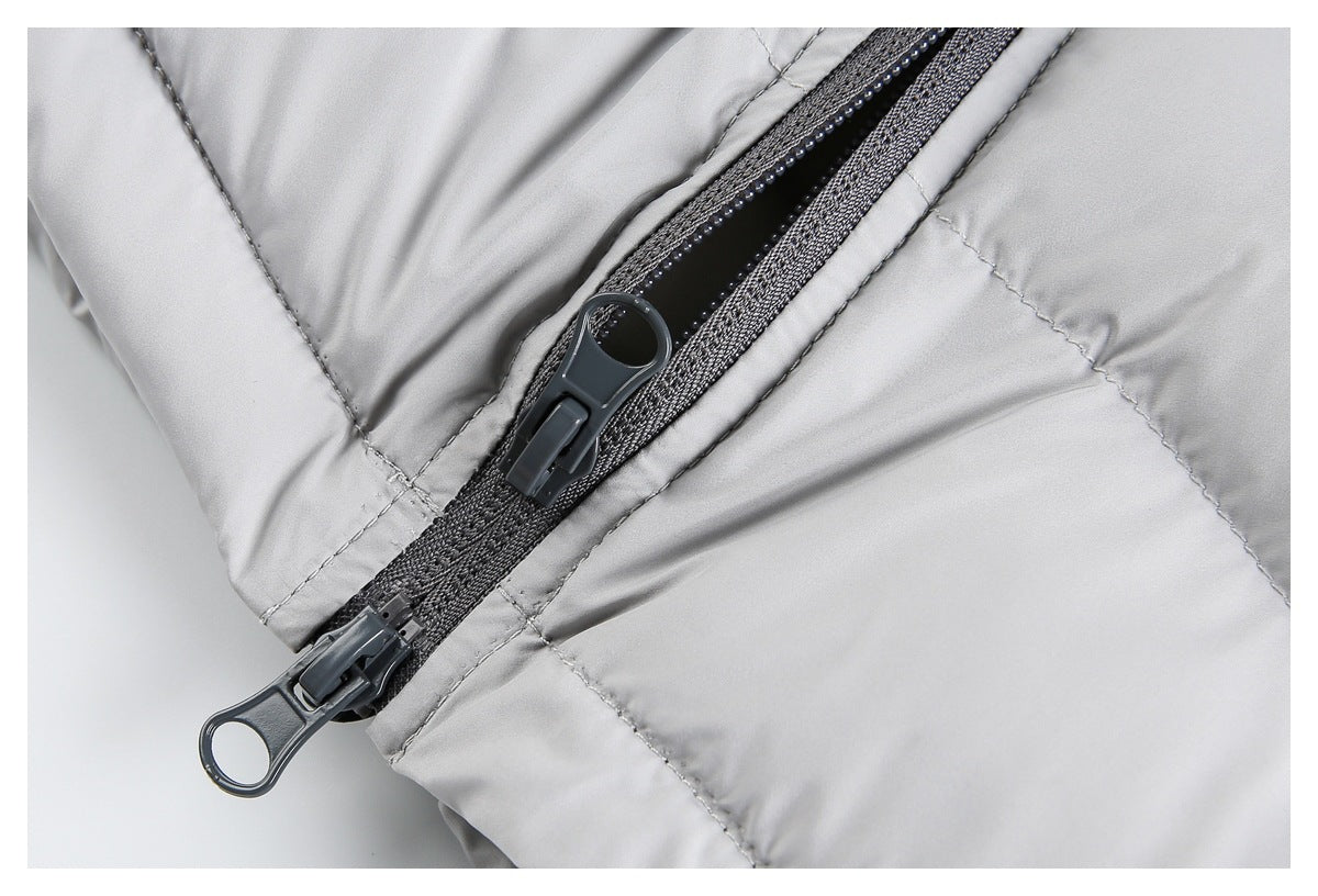 Close-up of the light gray jacket's dark two-way front zipper and quilted stitching.