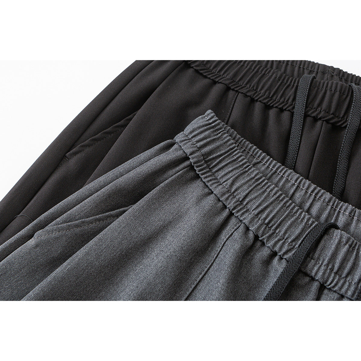 Close-up of dark wide-leg trousers showing the elastic waistband, black drawstring, and gathered fabric.