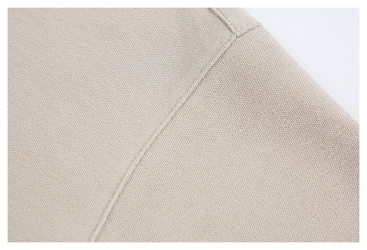 Close-up of beige garment fabric and a stitched seam.