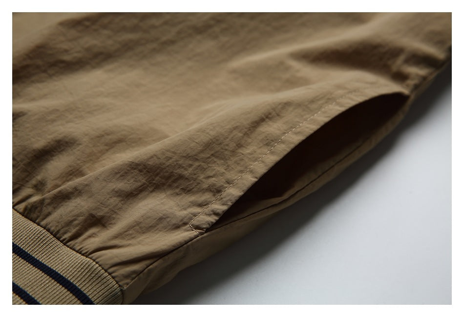 Close-up of a tan garment's side seam and hem opening.