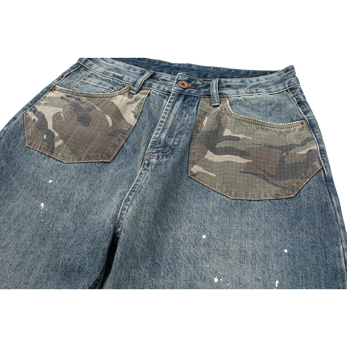 Close-up of blue jeans with camouflage front pockets, a button fly, and scattered white paint splatters.