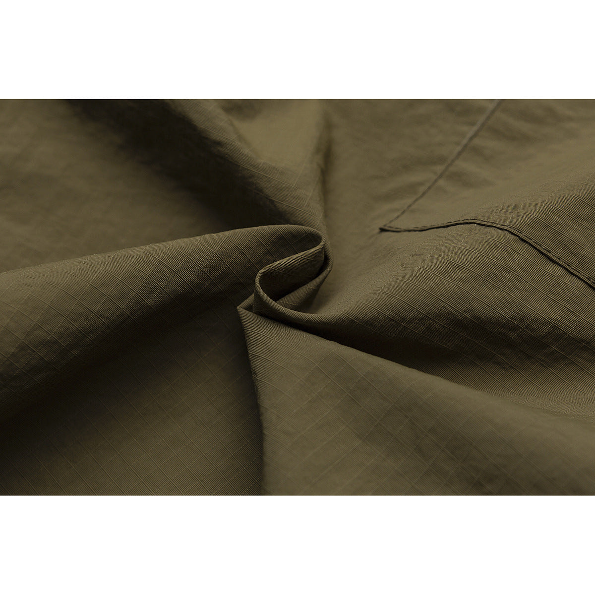 Extreme close-up of olive fabric showing its fine grid texture, folds, and stitching.