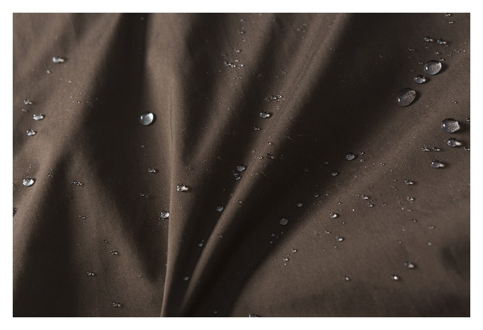 Water droplets rest on the surface of dark brown garment fabric.