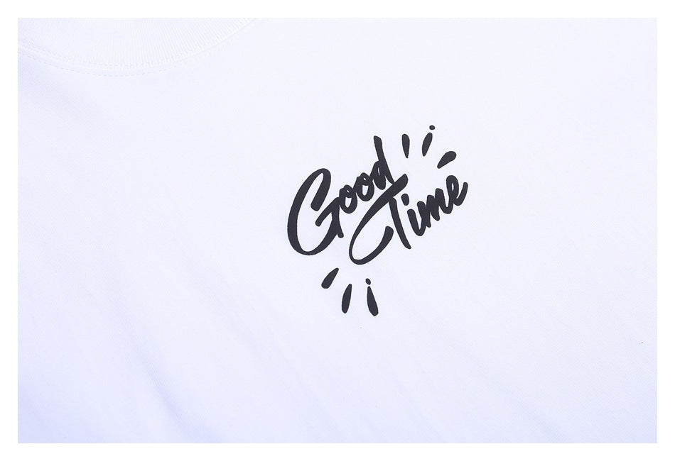 Close-up of a white T-shirt with black script reading “Good Time” on the chest.