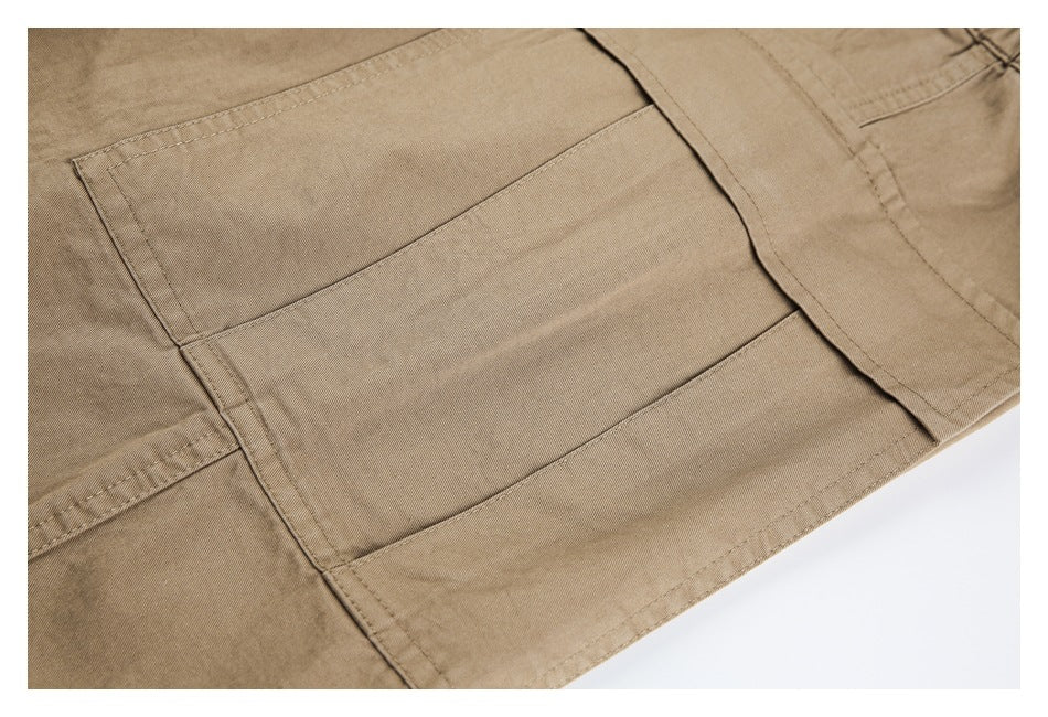 Close-up of tan trousers with a large stitched patch pocket.
