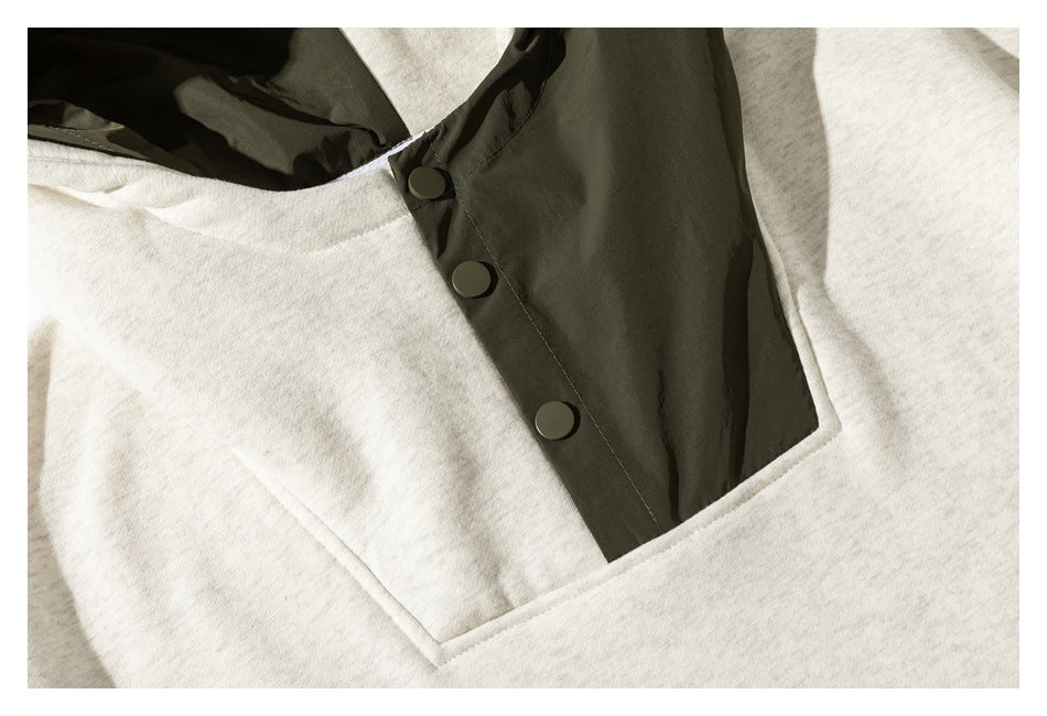 Close-up of the off-white hoodie’s olive snap-button placket and large front pouch pocket.