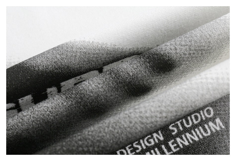 Macro view of textured black-and-white garment print with partial English lettering.