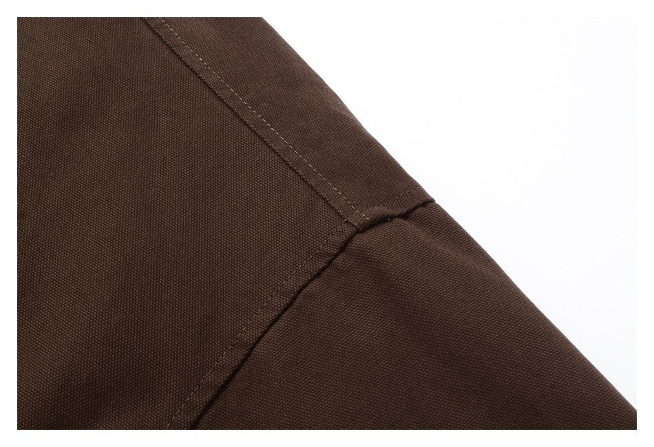 Close-up of the dark brown jacket’s stitched sleeve and panel seams.