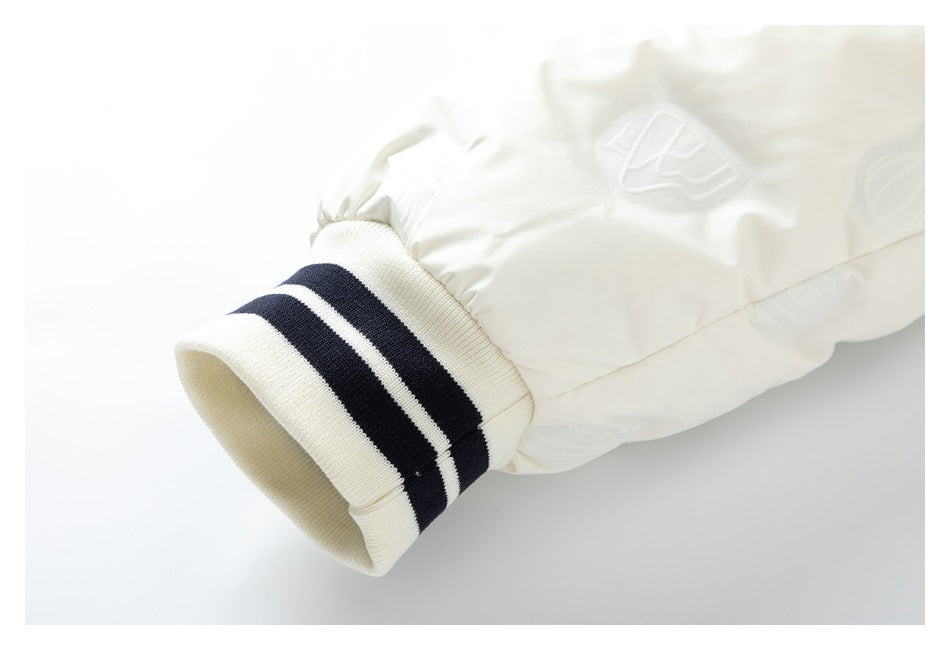 Close-up of a white sleeve with a ribbed cream cuff, two navy stripes and an embossed emblem.