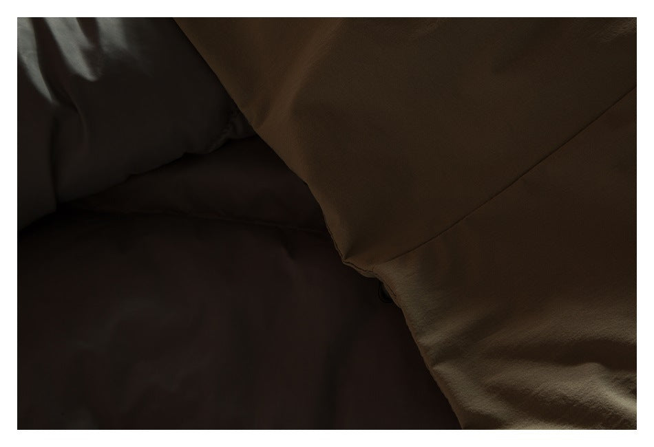 Dark close-up of overlapping olive-brown garment panels and a seam.