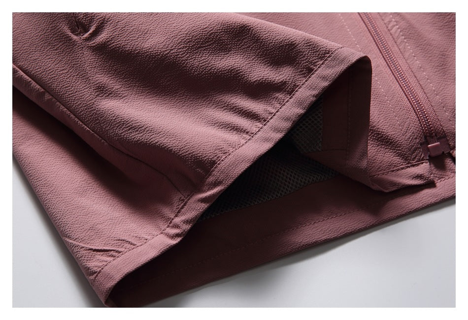 Close-up of a dusty rose garment hem, textured fabric, mesh lining, and zipper.