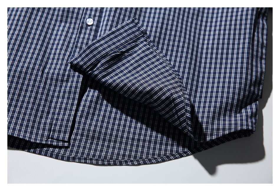 Close-up of a folded sleeve and cuff on a navy-and-white plaid shirt.