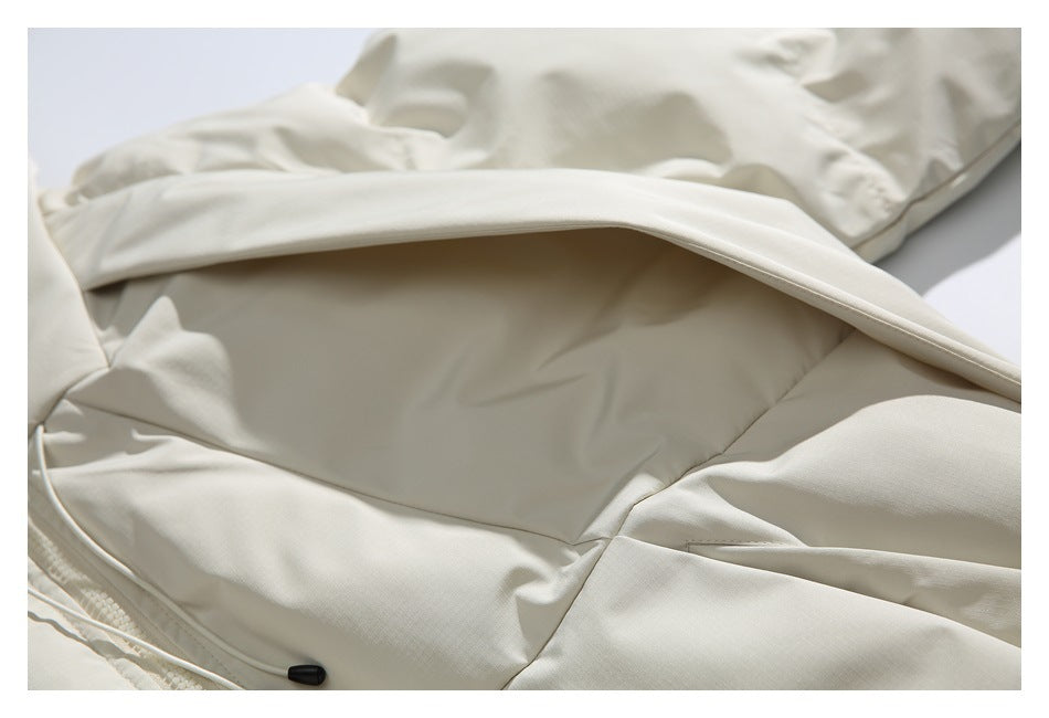 Close-up of the ivory jacket's hood and inner collar with a drawcord toggle.