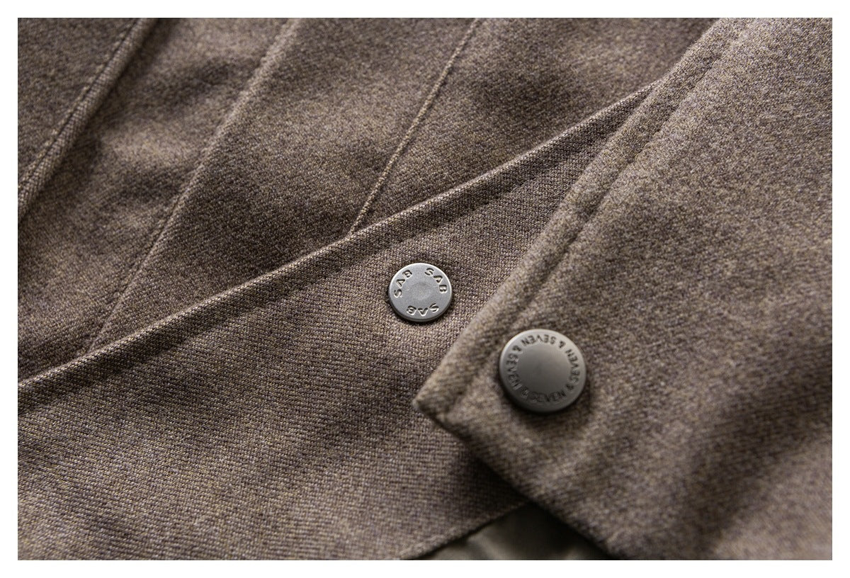 Close-up of brown-gray garment panels with two round metal buttons and visible stitching.