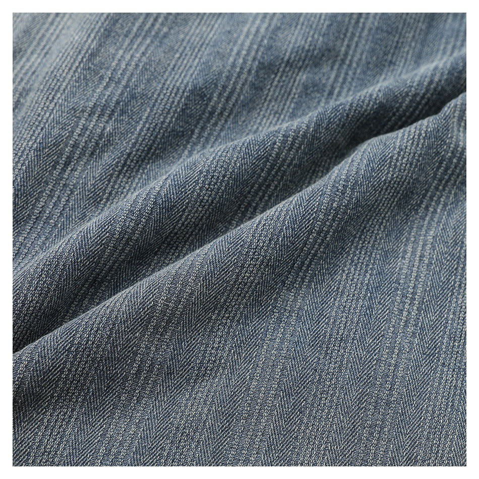 Close-up of the gray-blue jacket’s fine striped fabric draped into soft folds.
