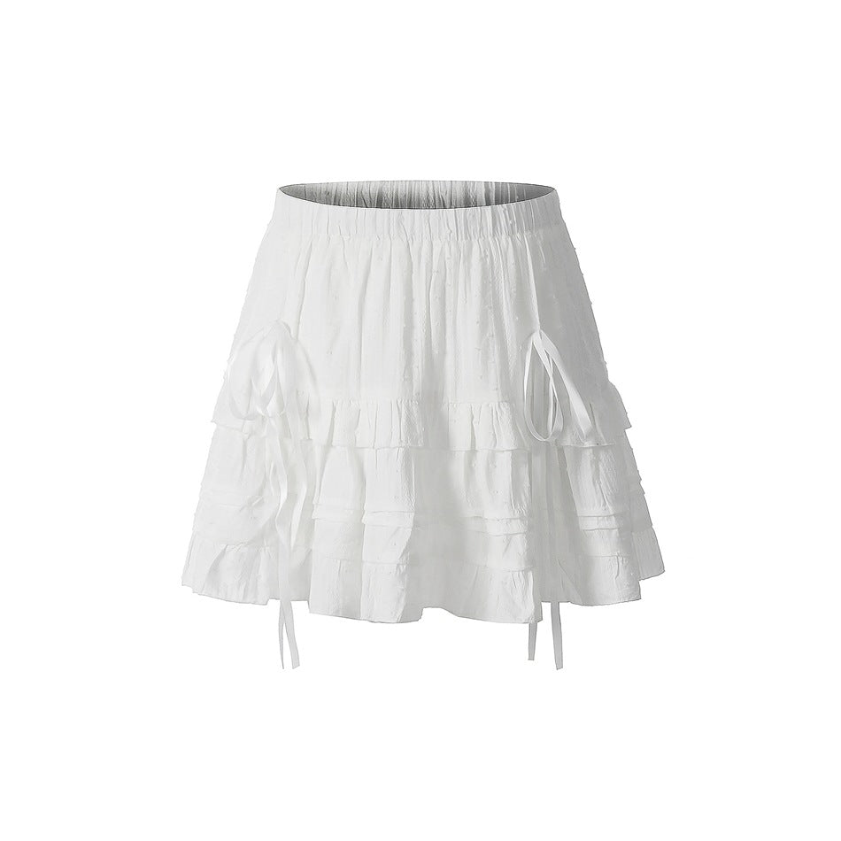 White tiered ruffle mini skirt with elastic waist and ribbon ties, front view on a plain white background