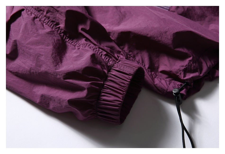 Close-up of a plum jacket's elastic cuff and adjustable hem drawcord.