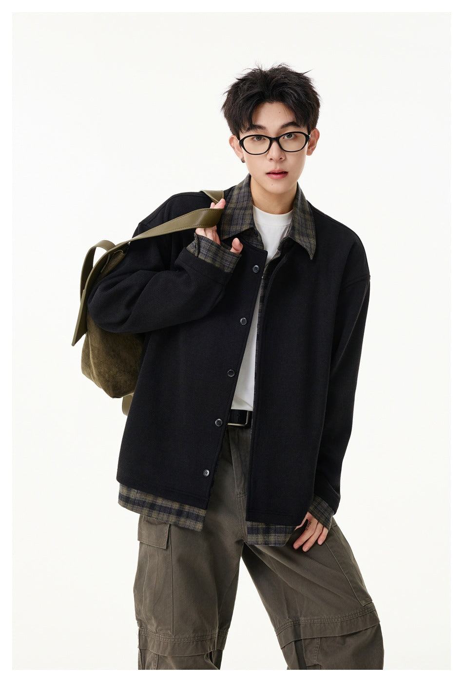 Model wearing a black button jacket with plaid collar, cuffs and hem, shown from the front.