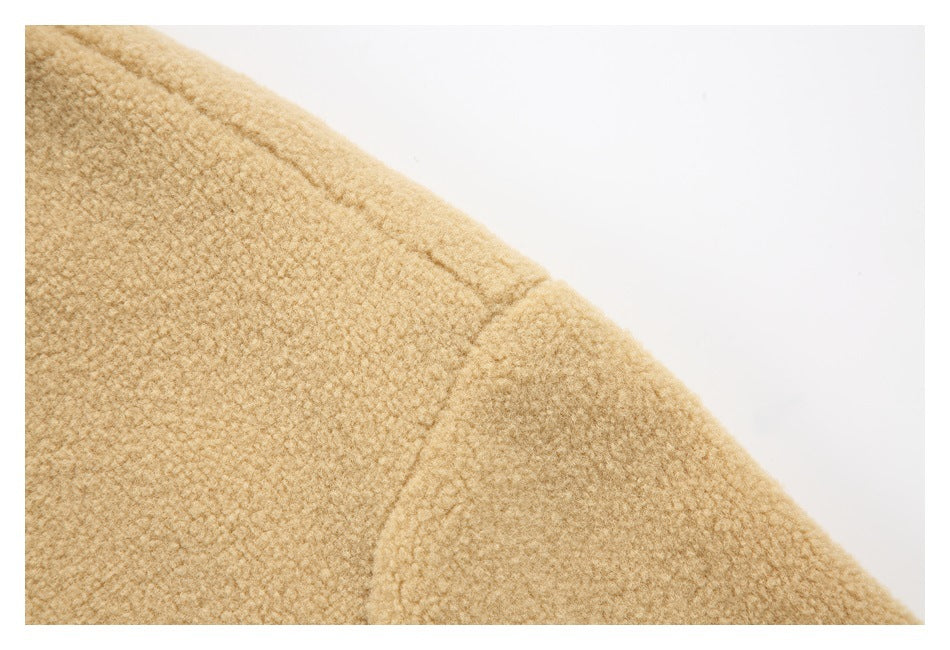 Close-up of tan fleece fabric and a curved shoulder seam.