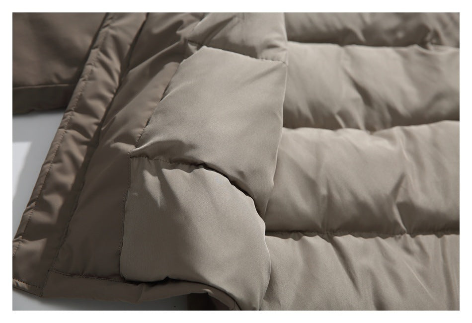 Close-up of the taupe padded jacket's stitched pocket flap and horizontal quilted panels.