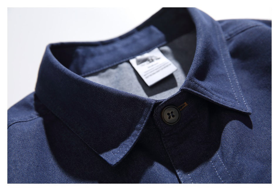 Close-up of the navy shirt’s pointed collar, top button and inner neck label.