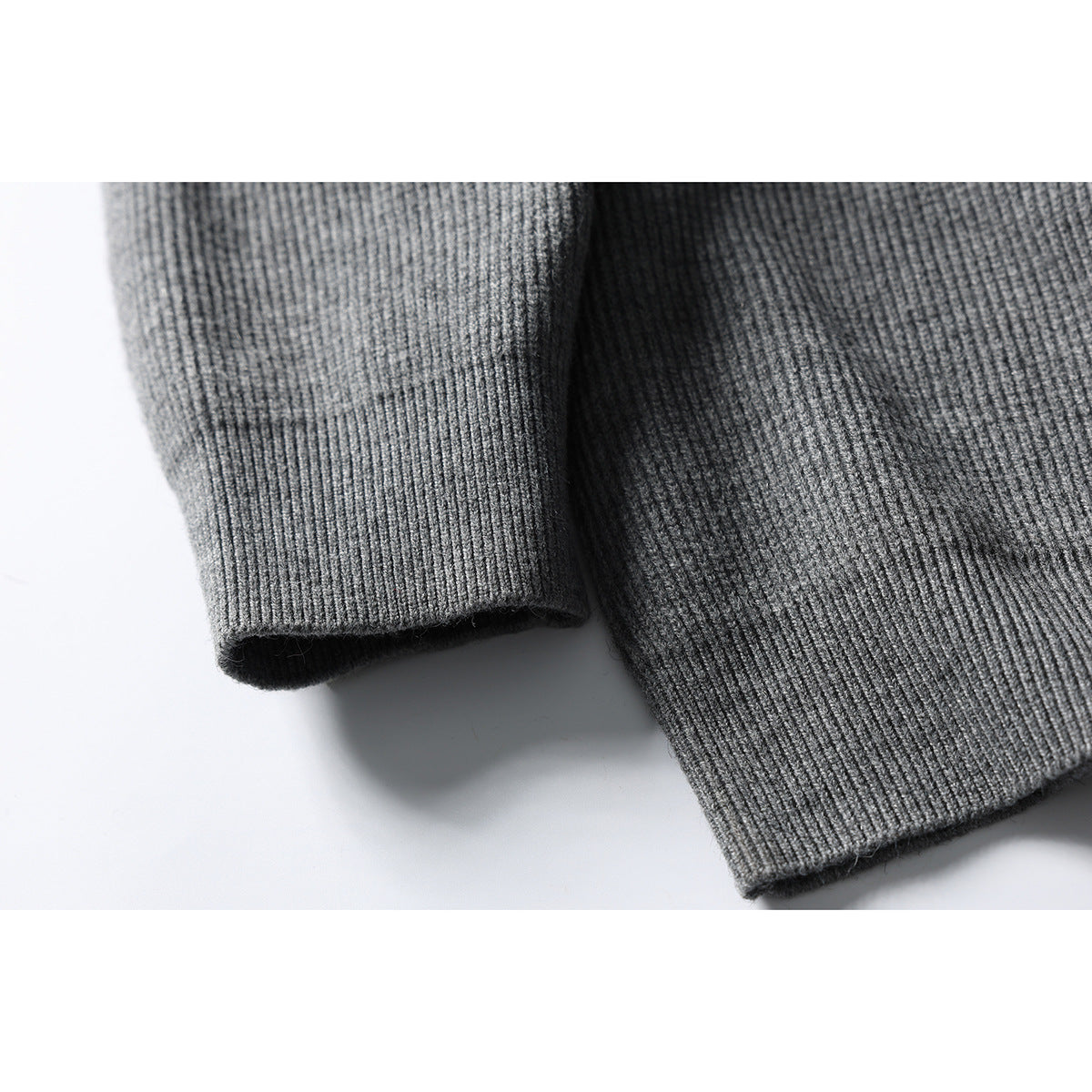 Close-up of the gray sweater's ribbed sleeve cuff and hem.