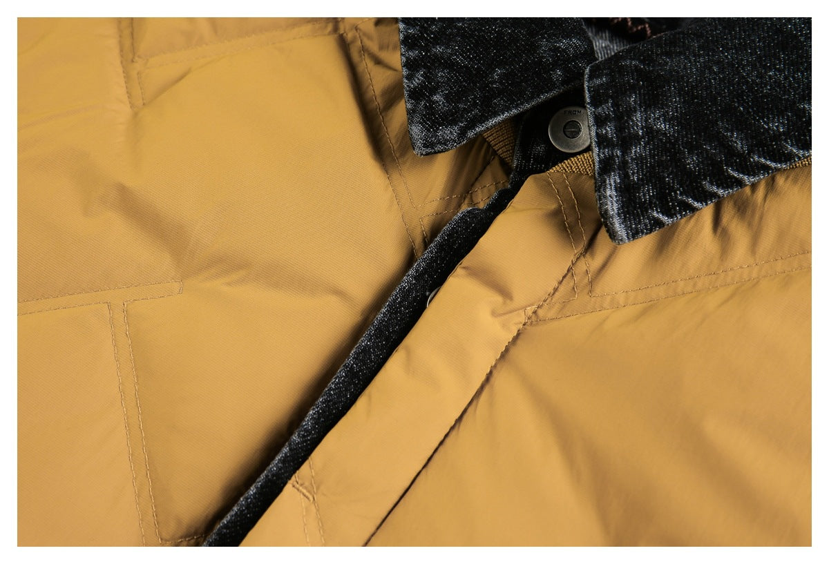 Close-up of a mustard garment with dark textured trim, stitching, and a metal button.