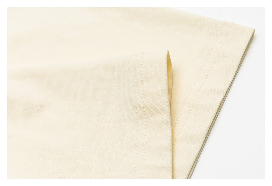 Close-up of an ivory T-shirt sleeve and stitched hem.