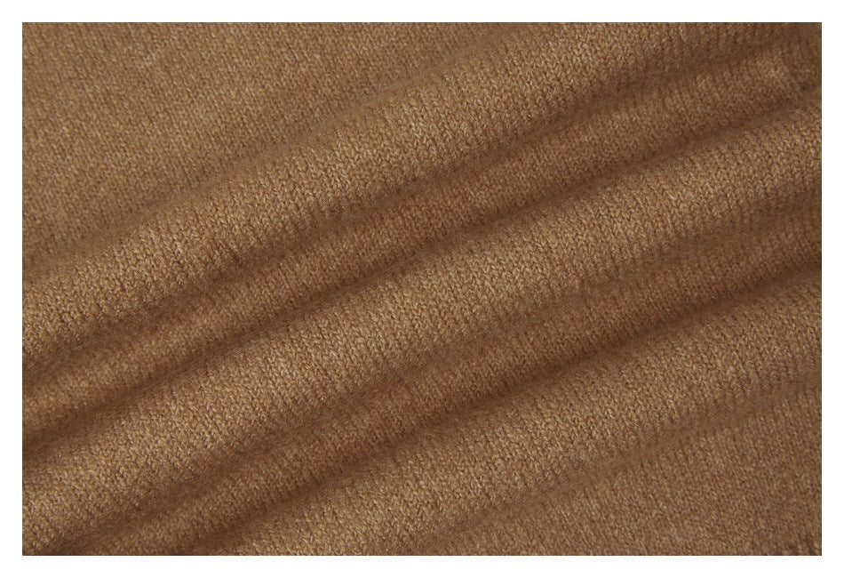 Extreme close-up of the tan sweater's knit texture.