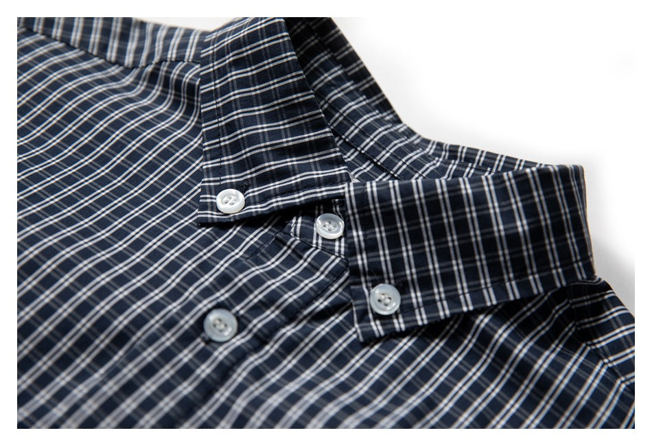 Close-up of a navy plaid shirt collar and white buttons.