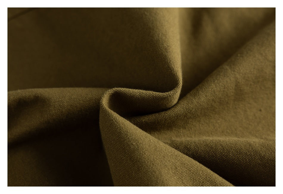 Close-up of olive-brown textured fabric gathered into soft folds.