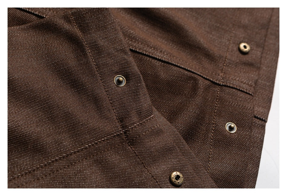 Close-up of dark brown trousers showing stitched panels and several metal snap fasteners.