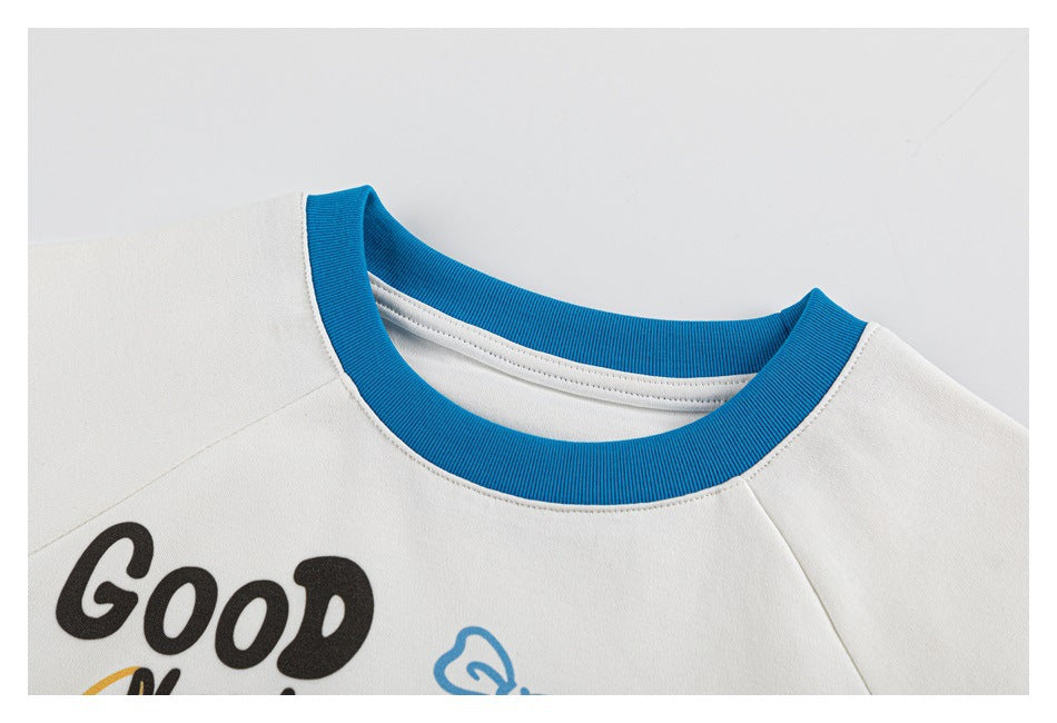 Close-up of the shirt's round neckline with bright blue ribbed trim and part of the printed design.