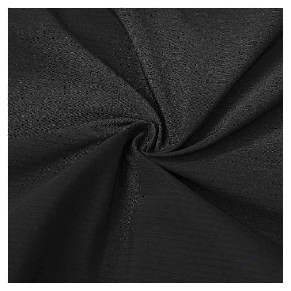 Close-up of black fabric gathered into a spiral, showing its fine woven texture.