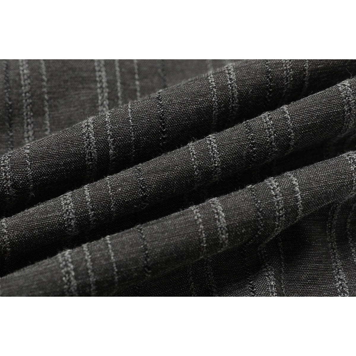 Macro view of charcoal fabric with narrow, irregular light pinstripes and visible woven texture.