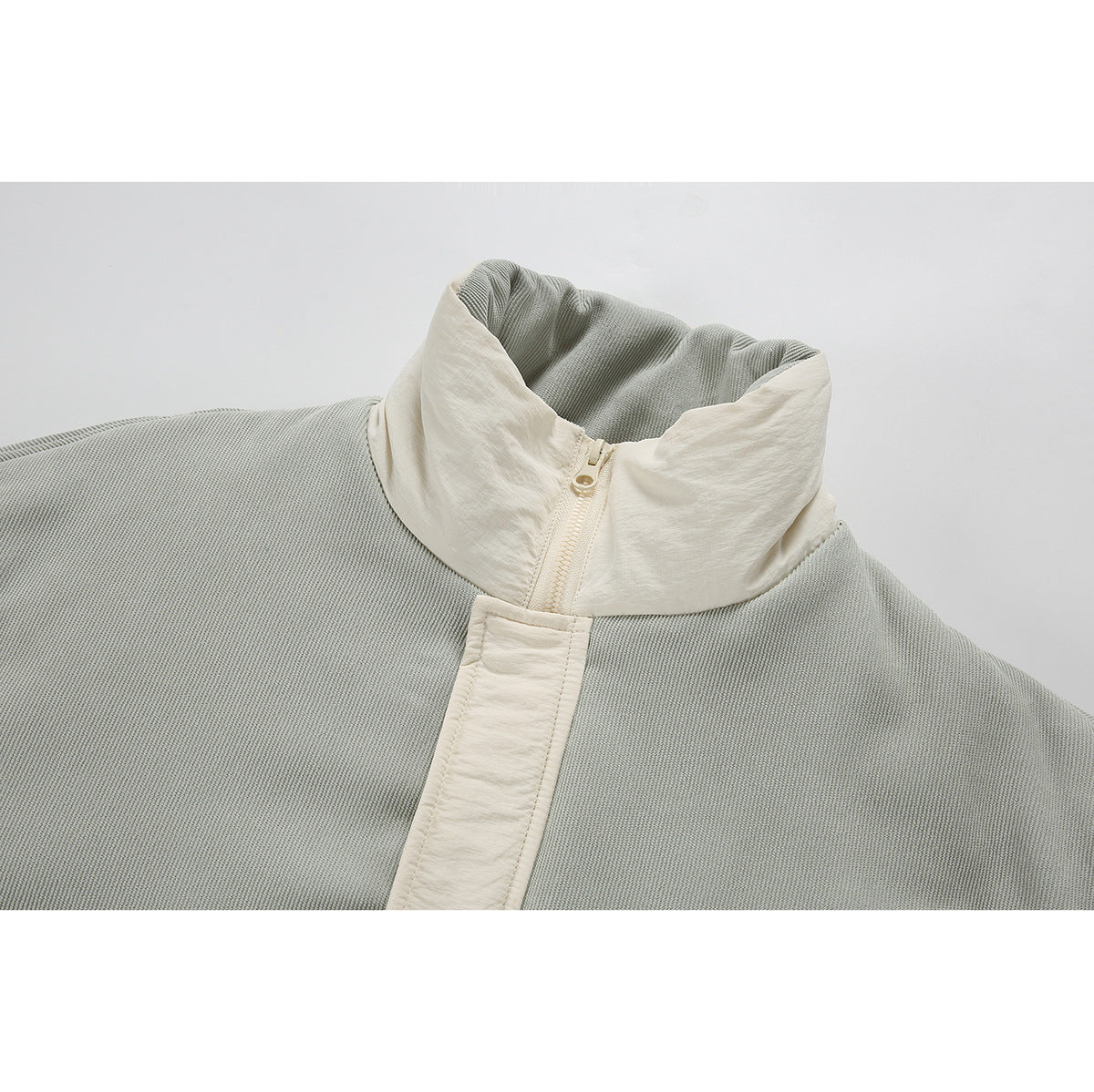 Close-up of a pale sage and cream jacket collar, zipper, and front placket.