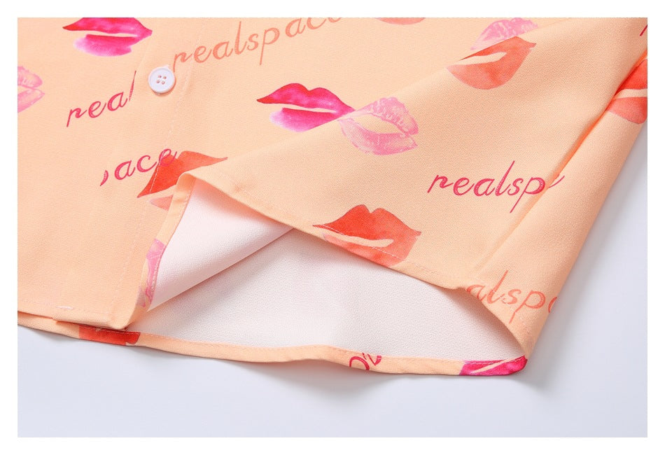 Close-up of the peach shirt's printed fabric, button, and folded hem showing the reverse side.