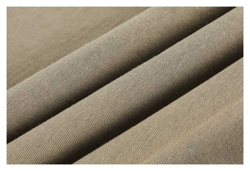 Close-up of tan fabric gathered into soft folds, showing its fine knit texture.