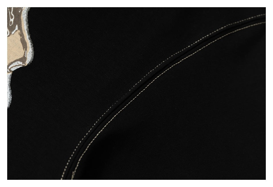 Close-up of double contrasting stitching along a seam on black T-shirt fabric.