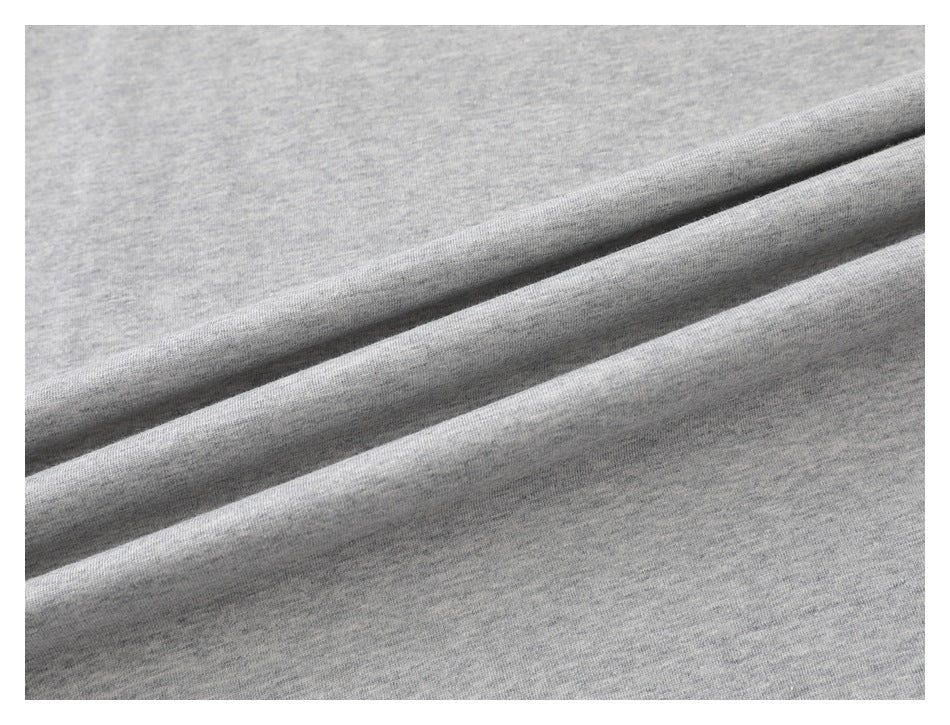 Close-up of light gray knit fabric folded into diagonal ridges.