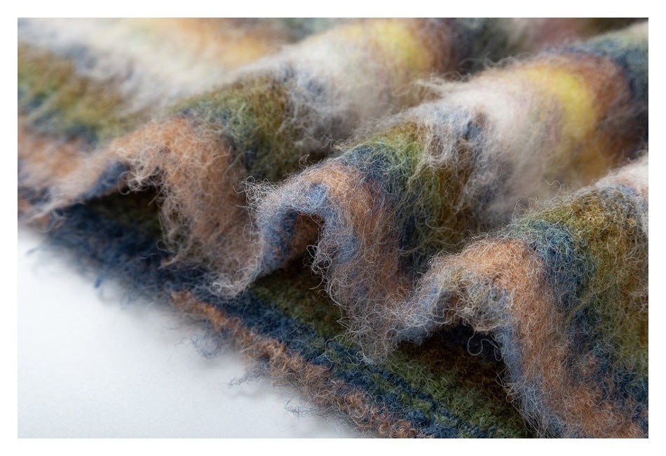 Macro view of plush, fuzzy striped fabric in muted blue, olive, brown, cream, and yellow tones.
