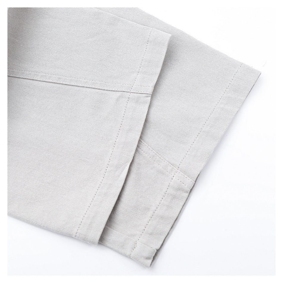 Close-up of light gray pants showing folded leg hems and stitched seams.