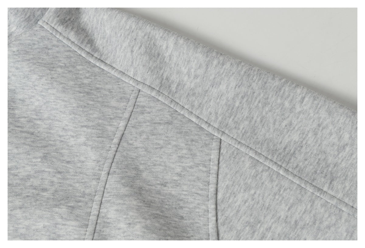 Close-up of stitched panel seams on light gray heather fabric.